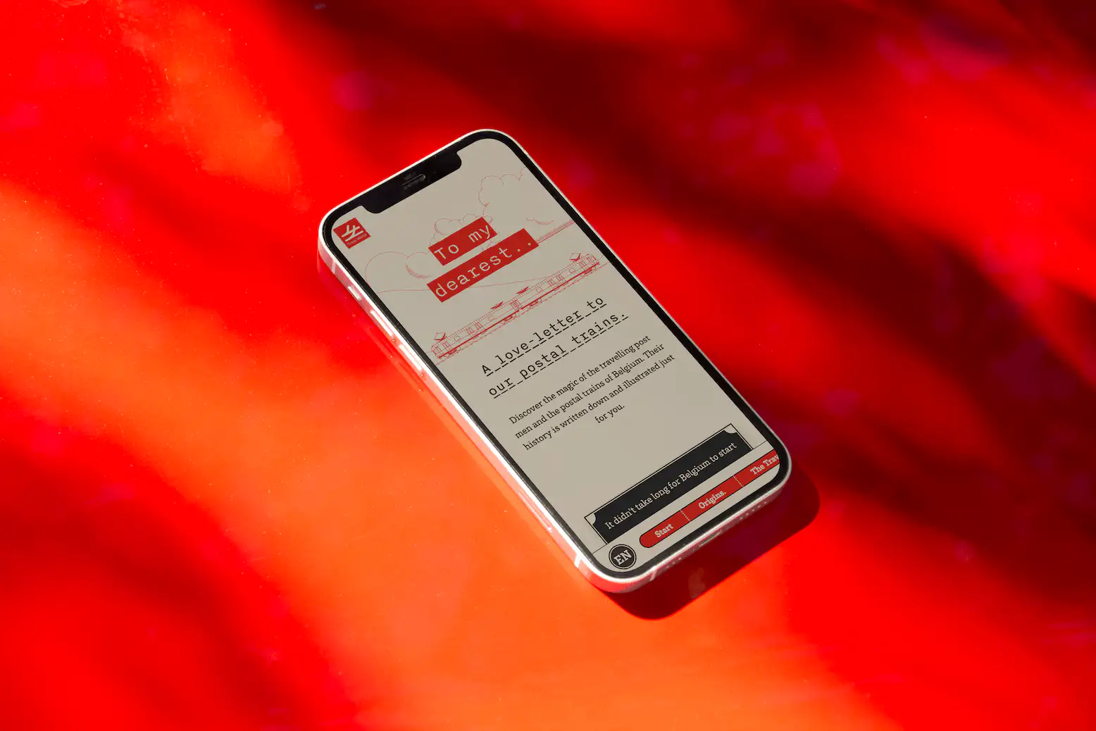 A mockup of a laptop with the Train World website open. It shows a train wagon with a red background and the text: 'To my dearest... A love letter to our postal trains'.'