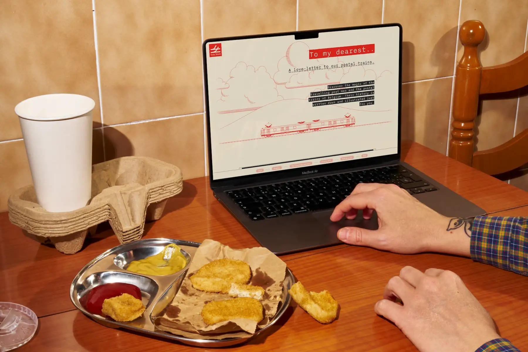 A mockup of a phone with the Train World website open. It shows a train wagon with a red background and the text: 'To my dearest... A love letter to our postal trains'.'